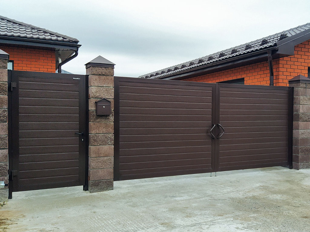 Распашные ворота с горизонтальным расположением панелей. Дизайн — «доска», цвет полотна — RAL 8017 (коричнево-красный), цвет окантовки — RAL 8017 (коричнево-красный)